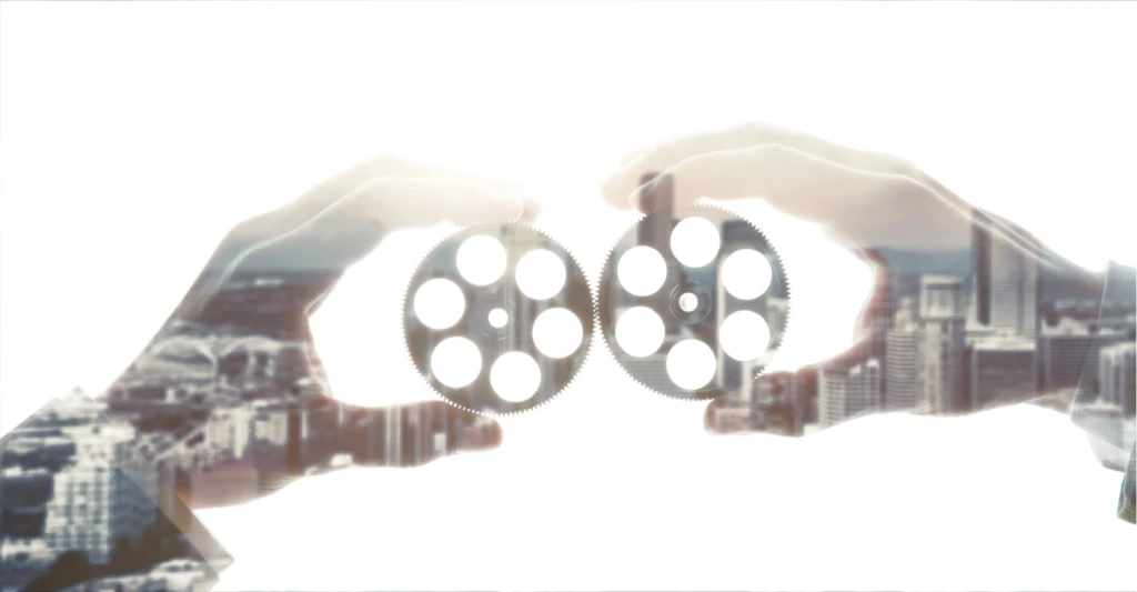 Hands holding gears symbolizing collaboration in the social sector, supporting development sector film services for NGOs and non profit work.