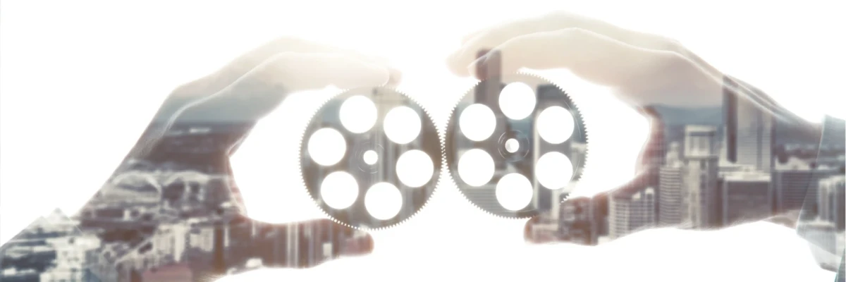 Hands holding gears symbolizing collaboration in the social sector, supporting development sector film services for NGOs and non profit work.