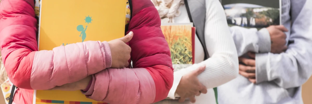 People holding notebooks and books, representing real field documentation for NGO and CSR annual report in India